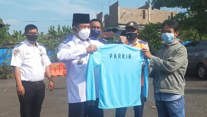 Serahkan Baju Kaos Kepada Pengelola Parkir